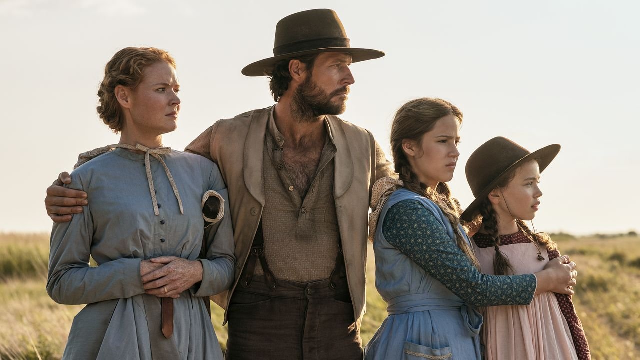 "A family stands together and looks off to the distance. "